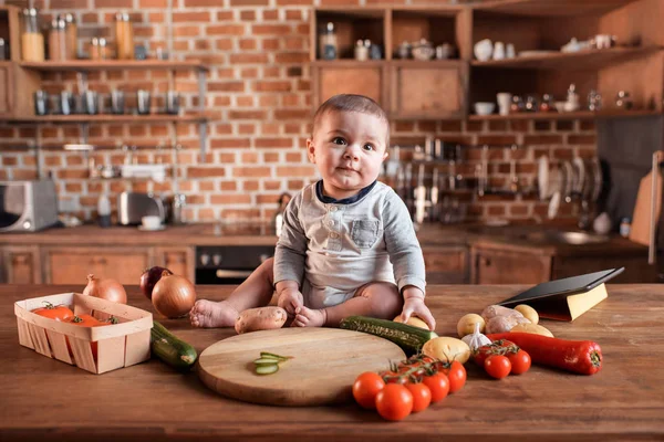 Mały chłopiec na stole w kuchni — Zdjęcie stockowe