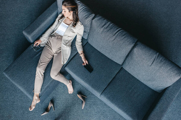 Уставшая деловая женщина отдыхает на диване
