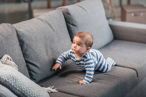 Menino rastejando no sofá — Fotografia de Stock