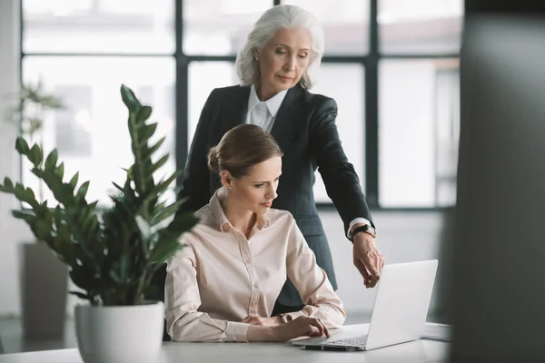 Businesswoman and her boss working with laptop — Stock Photo, Image