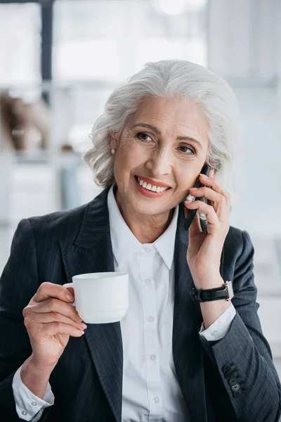 Senior zakenvrouw gebruikend smartphone — Stockfoto