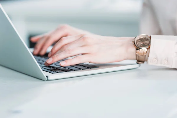 Bizneswoman z rąk zegarki pracy na laptopie — Zdjęcie stockowe