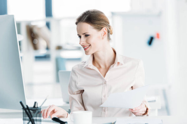 businesswoman working with documents and computer at office