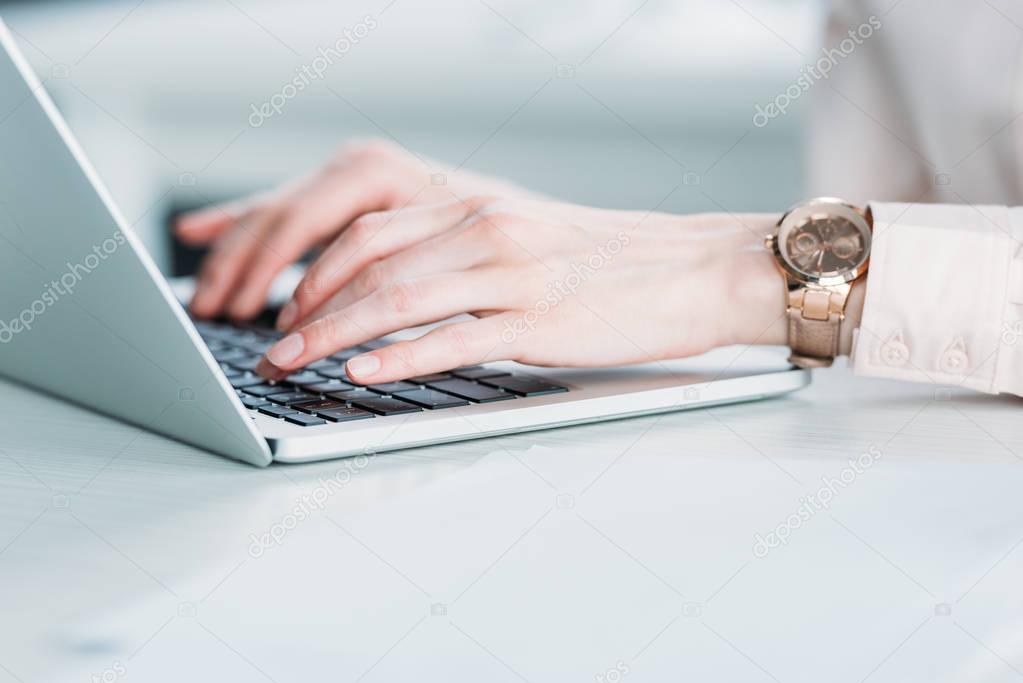 businesswoman with hand watches working on laptop