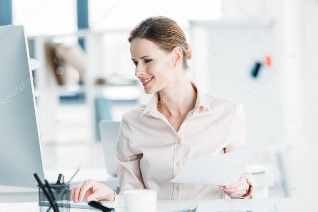 businesswoman working with documents and computer at office