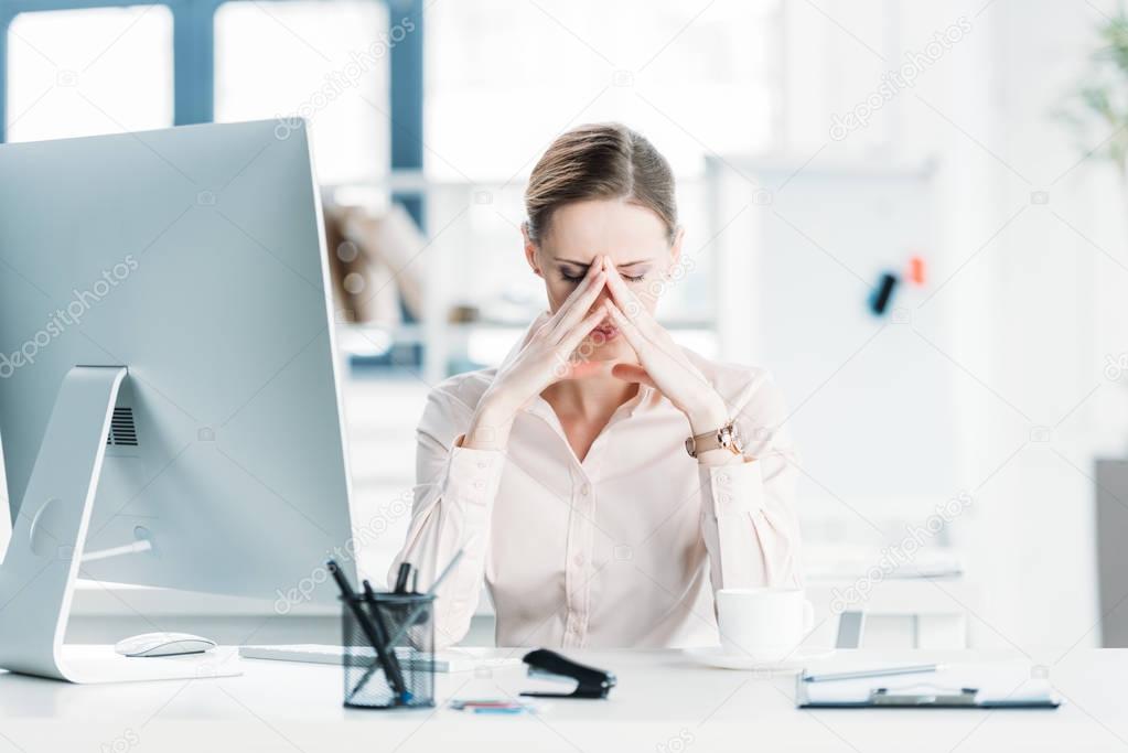 tired businesswoman sitting at office