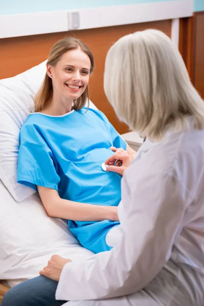 Doctor listening belly of pregnant woman — Stock Photo, Image