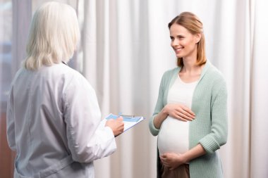 doctor with pregnant woman during consultation clipart