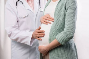 Doktor hamile kadını muayene ediyor.