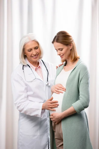 Médico examinando jovem mulher grávida — Fotografia de Stock