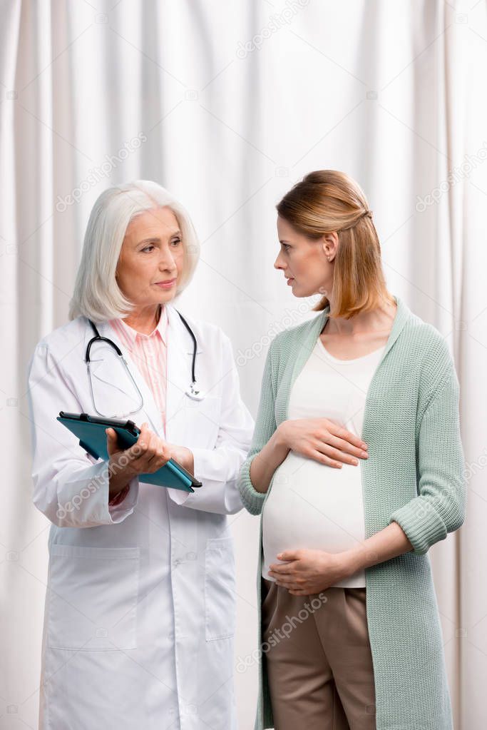 doctor talking with young pregnant woman
