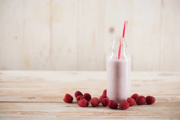 Raspberry milkshake with straw in glass — Stock Photo, Image