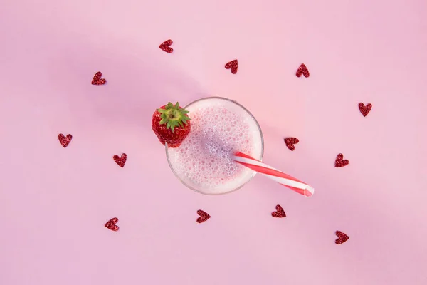 Полуничний молочний коктейль у склянці з питною соломою — стокове фото