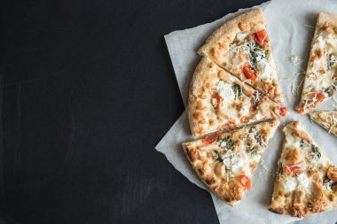 geleneksel İtalyan pizza parşömen üzerine dilimlenmiş