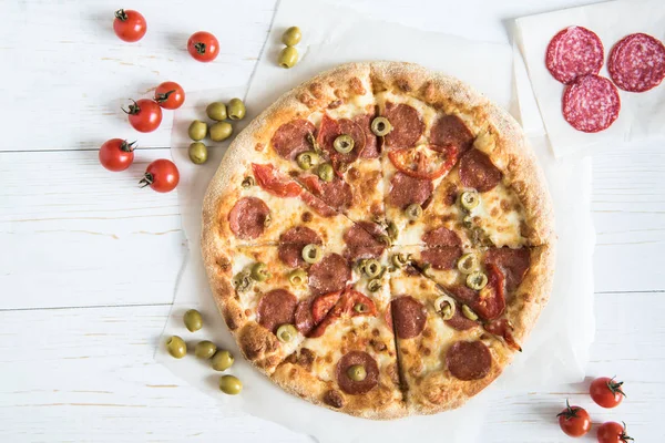 Italian pizza with ingredients on tabletop — Stock Photo, Image