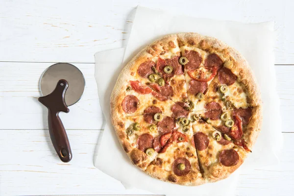 Italian pizza and pizza cutter — Stock Photo, Image