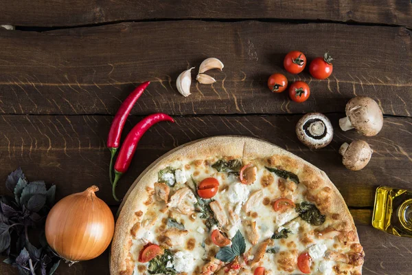 Italian pizza with ingredients on tabletop — Stock Photo, Image