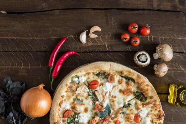 Italienische Pizza mit Zutaten auf Tischplatte — Stockfoto