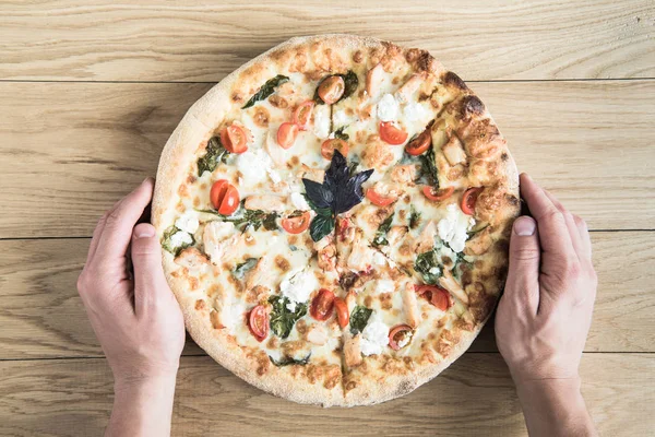 Händer som håller italiensk pizza — Stockfoto