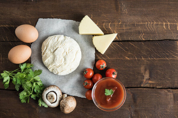 dough with ingredients for preparing pizza