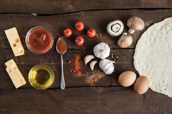 ingredients for preparing pizza on wooden tabletop