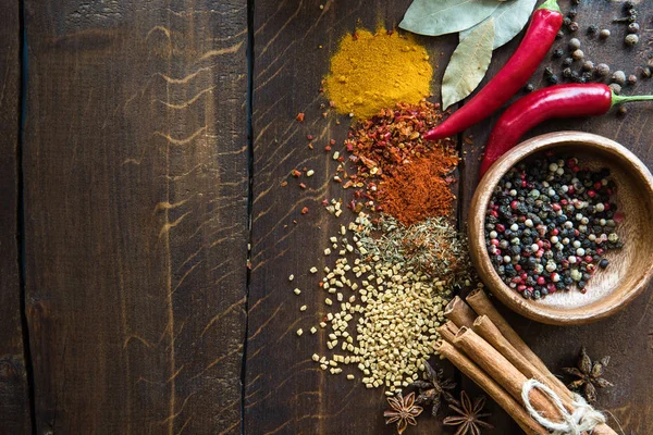 Pepper in bowl with scattered herbs and spices — Stock Photo, Image