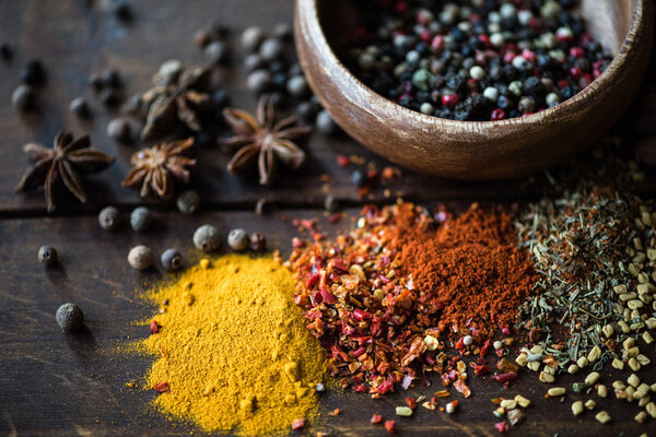 pepper in bowl and spices with herbs on tabletop