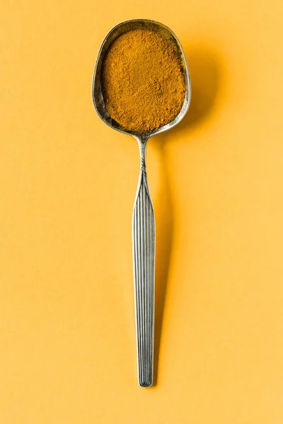 Металева ложка з порошком каррі — стокове фото