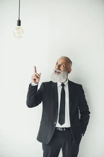 Businessman pointing at light bulb — Stock Photo, Image