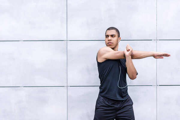 african american runner stretching on street