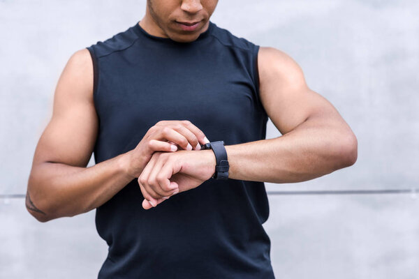 african american sportsman using smartwatch     