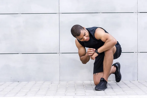 Африканский американский спортсмен с помощью умных часов — стоковое фото