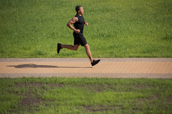 african american sportsman running in park