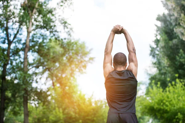 African american sportsman stretching in park — Stock Photo, Image