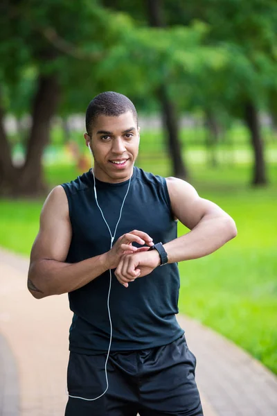 African american sportsman using smartwatch — Free Stock Photo