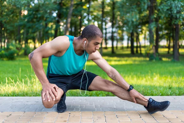 Afroamericano deportista estiramiento en parque — Foto de Stock