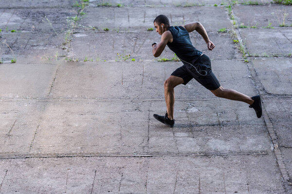 Африканский американский спортсмен бежит по улице
