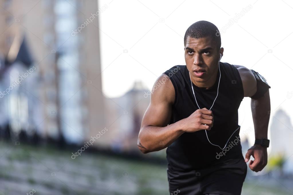 african american sportsman running on street