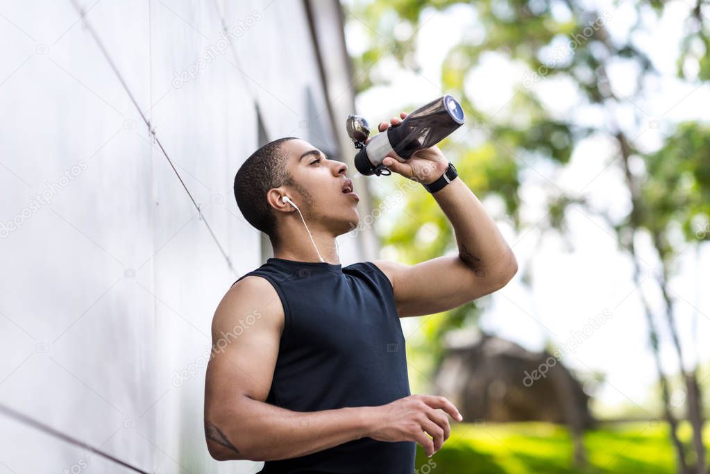 african american sportsman drinking water