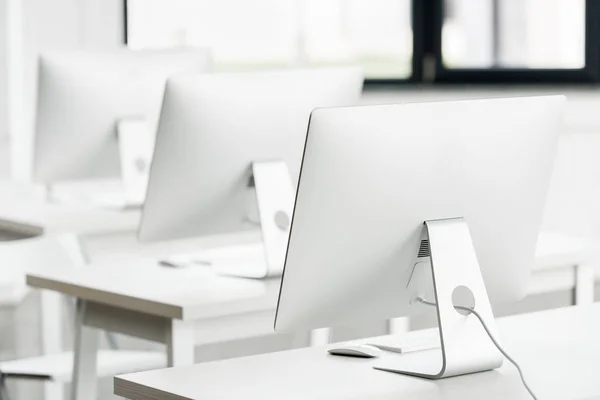 Computer monitors on tables in class — Stock Photo, Image