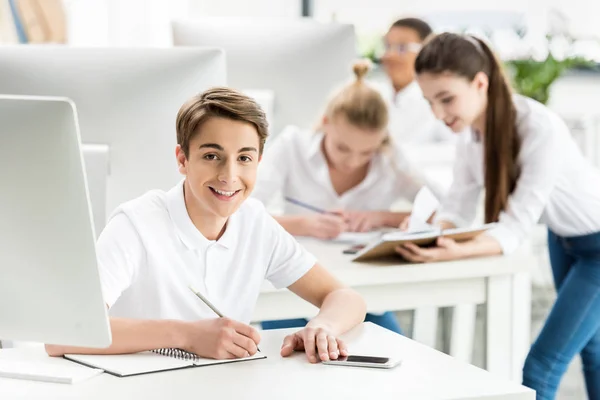 Smiling teenager in classroom — Stock Photo, Image