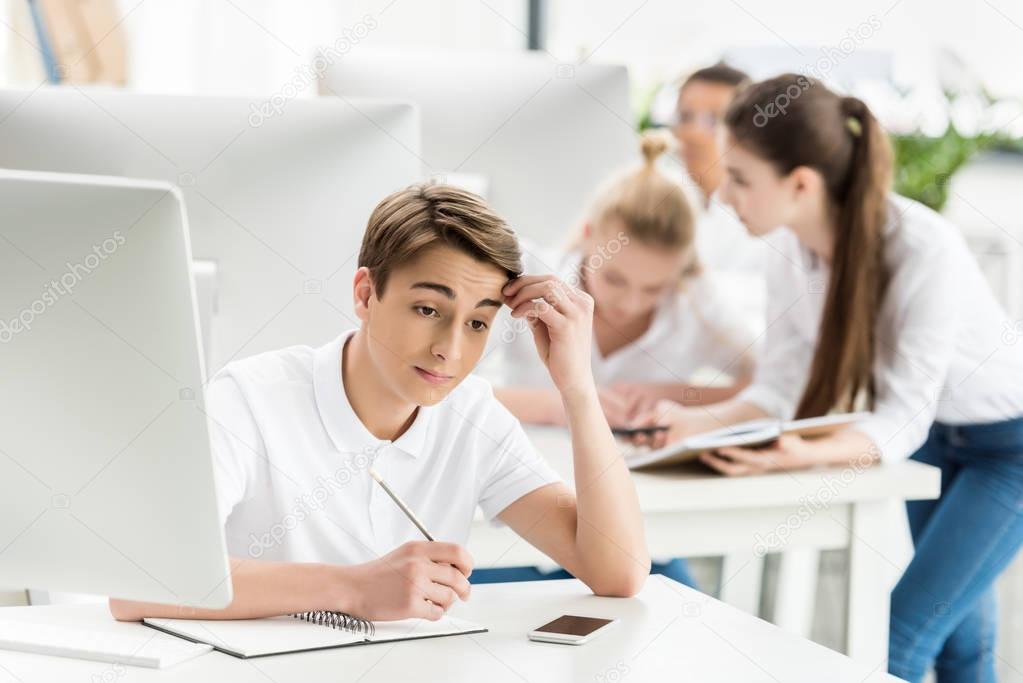 pensive teenage boy in classroom