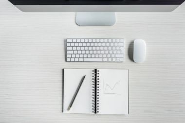 dijital cihazlar ve masa üstünde defter