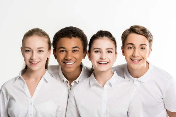 Sonrientes adolescentes multiétnicos en camisas blancas — Foto de Stock