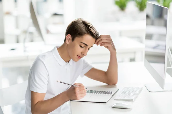 Estudiante enfocado haciendo tarea — Foto de Stock