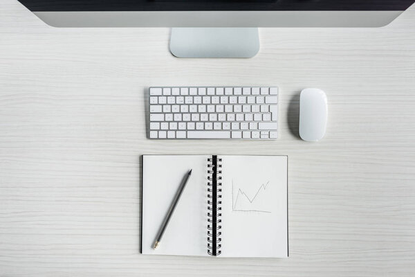 digital devices and notebook on table