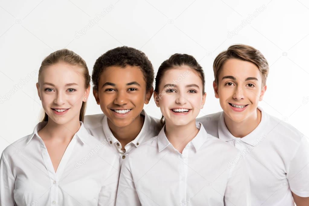 smiling multiethnic teenagers in white shirts