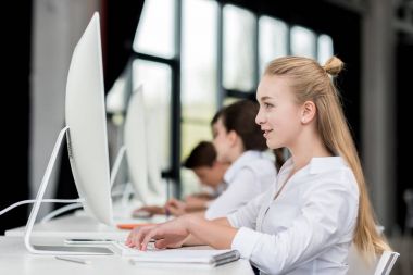 bilgisayarda çalışarak gülümseyen genç kız