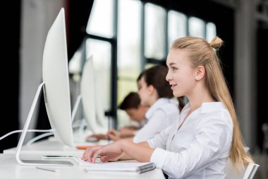 smiling teen girl working on computer clipart