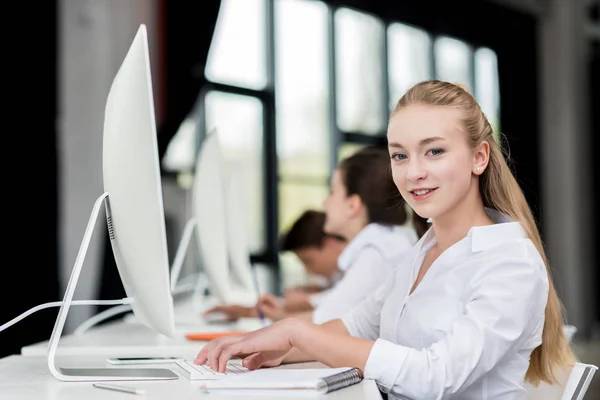 Gadis remaja tersenyum bekerja pada komputer — Stok Foto